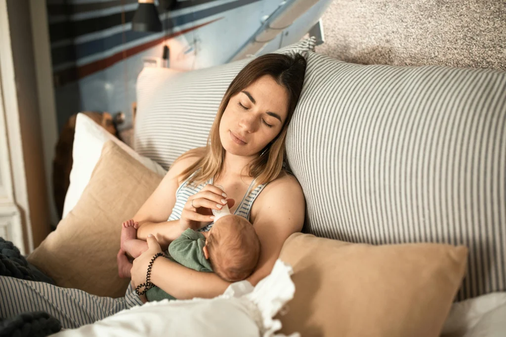 maman fatiguée qui donne le biberon à son bébé entre deux réunions